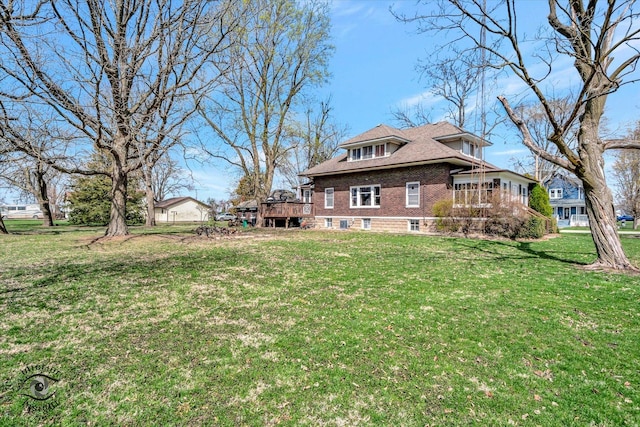 exterior space with a yard, a shingled roof, and a deck