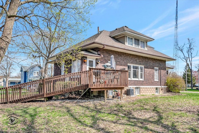 rear view of house with brick siding, central AC, and a wooden deck