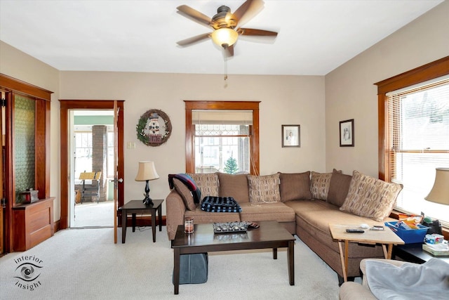 living area with light colored carpet and ceiling fan