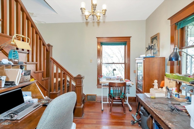 office area featuring a notable chandelier, visible vents, and wood finished floors