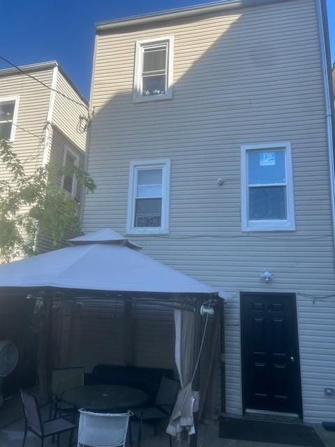 rear view of property featuring a gazebo