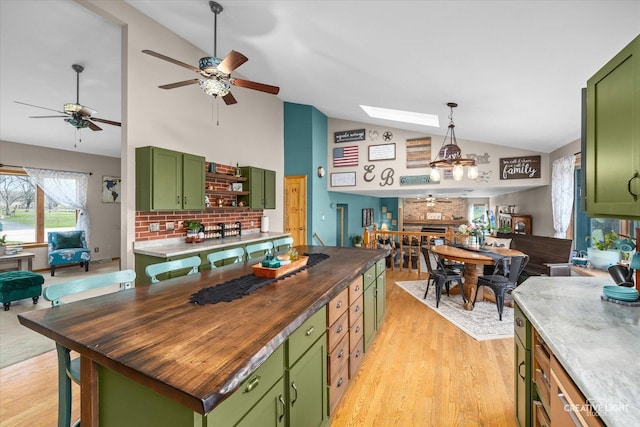 kitchen featuring open floor plan, green cabinets, and wooden counters
