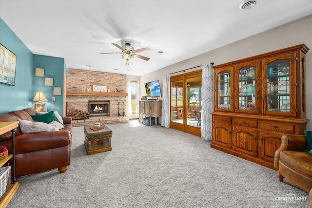carpeted living room with visible vents, a fireplace, and ceiling fan