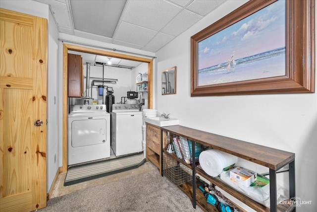 clothes washing area featuring light carpet, a sink, independent washer and dryer, and laundry area
