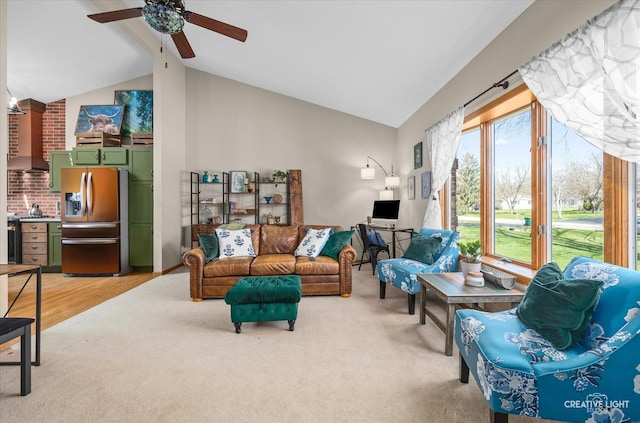 living area with light colored carpet, a ceiling fan, beamed ceiling, and high vaulted ceiling