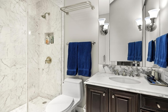 full bathroom with toilet, vanity, and tiled shower