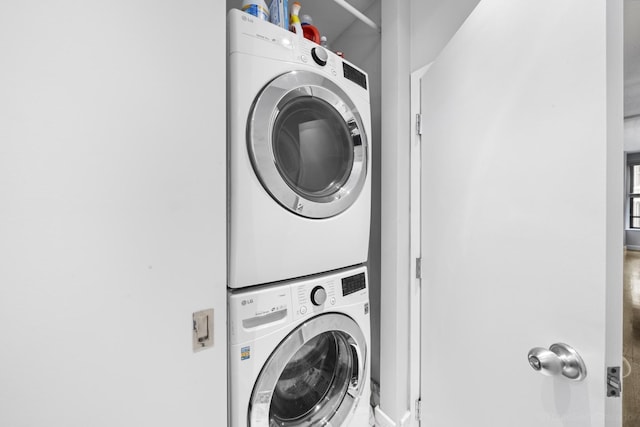 washroom with stacked washer and clothes dryer and laundry area
