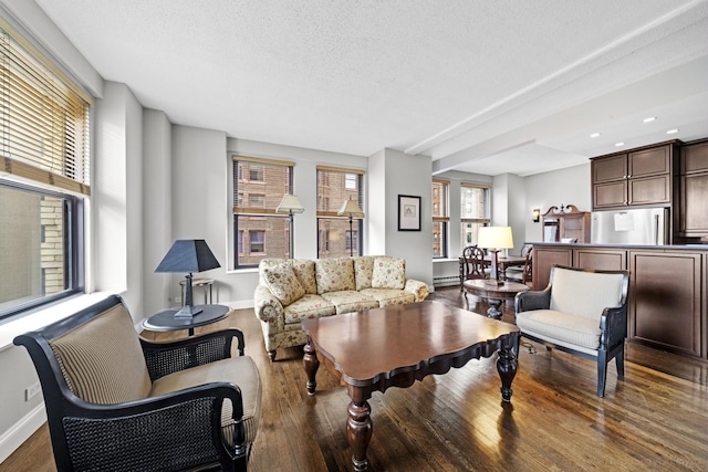 living area with baseboards, wood finished floors, and a textured ceiling