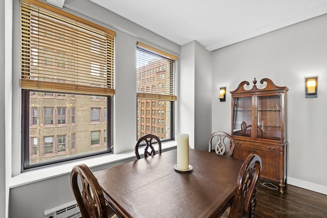 dining area with baseboards, dark wood-style floors, and a baseboard heating unit
