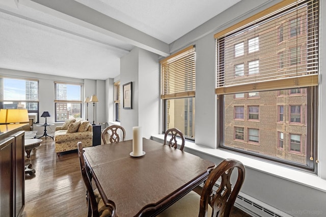dining area with a baseboard radiator, dark wood-style flooring, and beamed ceiling