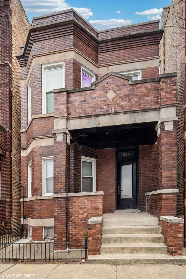 view of front facade with a fenced front yard and brick siding