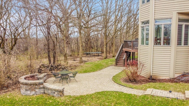 view of yard with a wooden deck, a patio area, stairs, and a trampoline