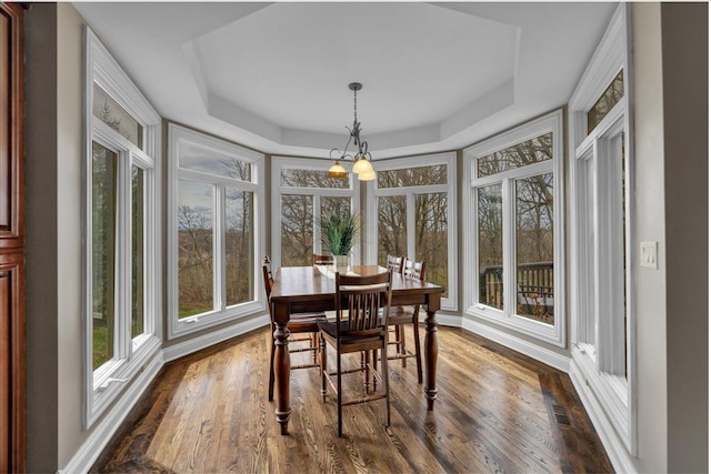sunroom featuring a tray ceiling and wood finished floors