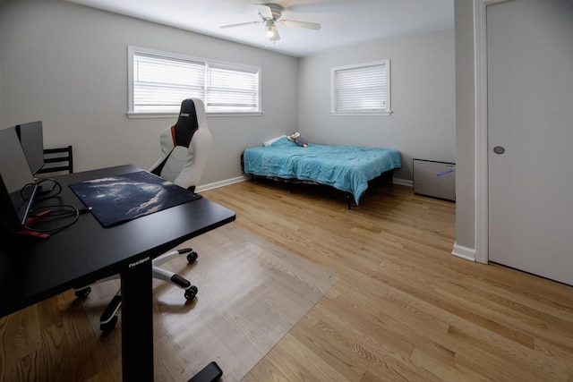 bedroom featuring baseboards, light wood finished floors, and ceiling fan