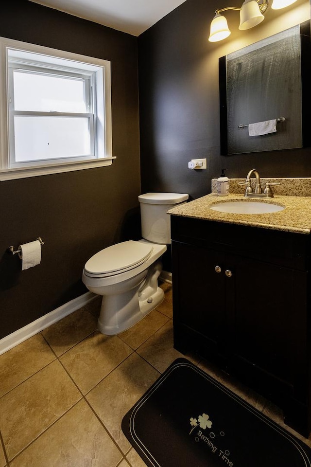 bathroom featuring toilet, vanity, tile patterned floors, and baseboards