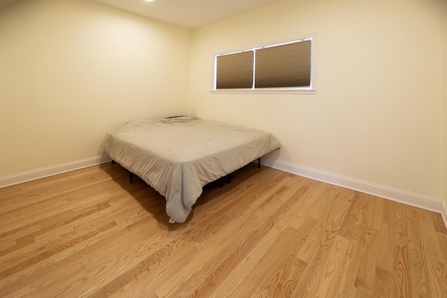 bedroom featuring baseboards and light wood-type flooring