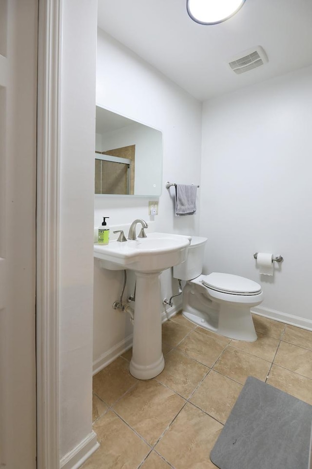 bathroom with baseboards, visible vents, toilet, and tile patterned flooring