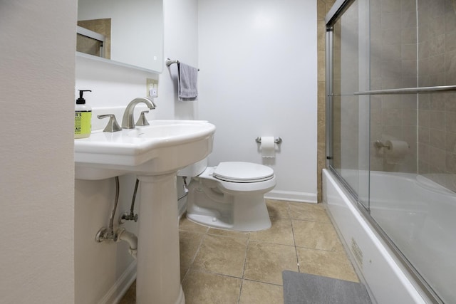 bathroom with baseboards, bath / shower combo with glass door, toilet, and tile patterned floors
