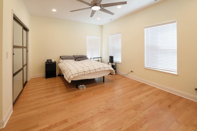 bedroom featuring baseboards, light wood-style flooring, and recessed lighting