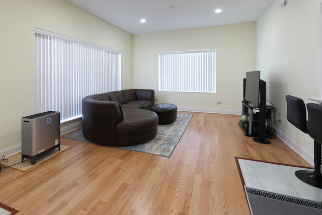 living room with recessed lighting, visible vents, baseboards, and wood finished floors