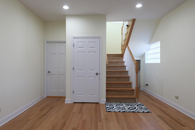 stairs featuring baseboards, wood finished floors, and recessed lighting