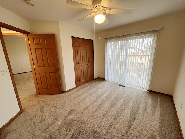 unfurnished bedroom with access to exterior, a closet, a ceiling fan, baseboards, and carpet