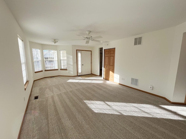 spare room featuring baseboards, visible vents, and light colored carpet