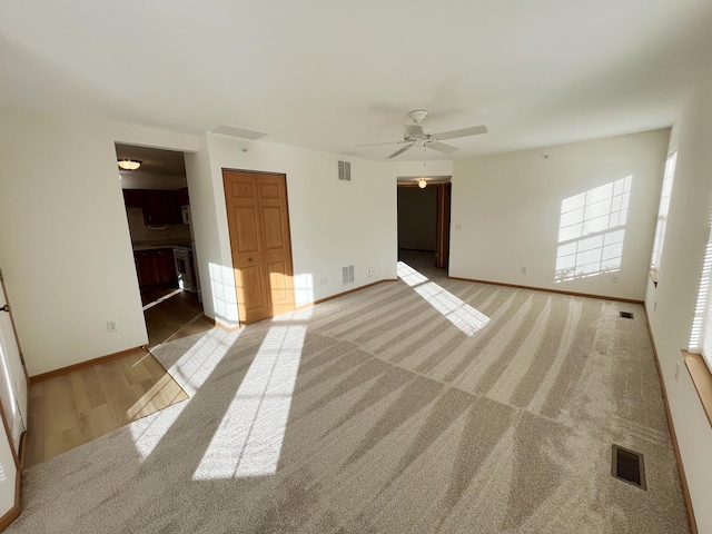 interior space with a ceiling fan, baseboards, and visible vents