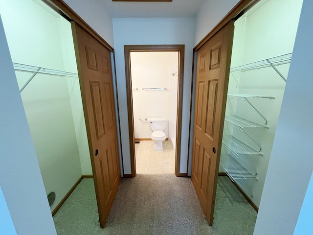 corridor with baseboards and carpet