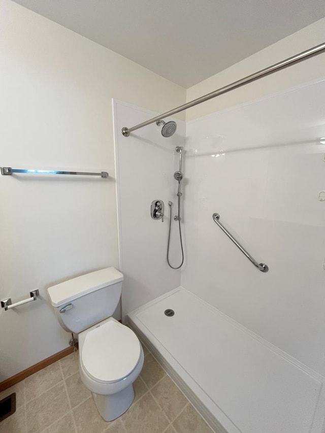 full bath featuring toilet, baseboards, and walk in shower