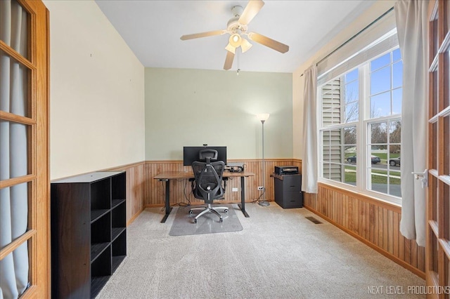 office area featuring wooden walls, wainscoting, visible vents, and carpet floors