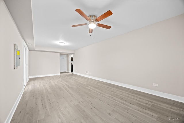 spare room featuring light wood finished floors, baseboards, and a ceiling fan
