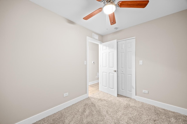 unfurnished bedroom with a closet, baseboards, visible vents, ceiling fan, and carpet