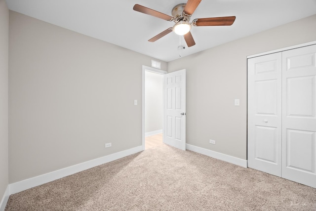 unfurnished bedroom with carpet flooring, baseboards, visible vents, a ceiling fan, and a closet