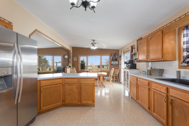 2956 Welland Rd, Earlville, IL 60518 - kitchen featuring stainless steel fridge, a peninsula, light countertops, brown cabinets, and ceiling fan with notable chandelier