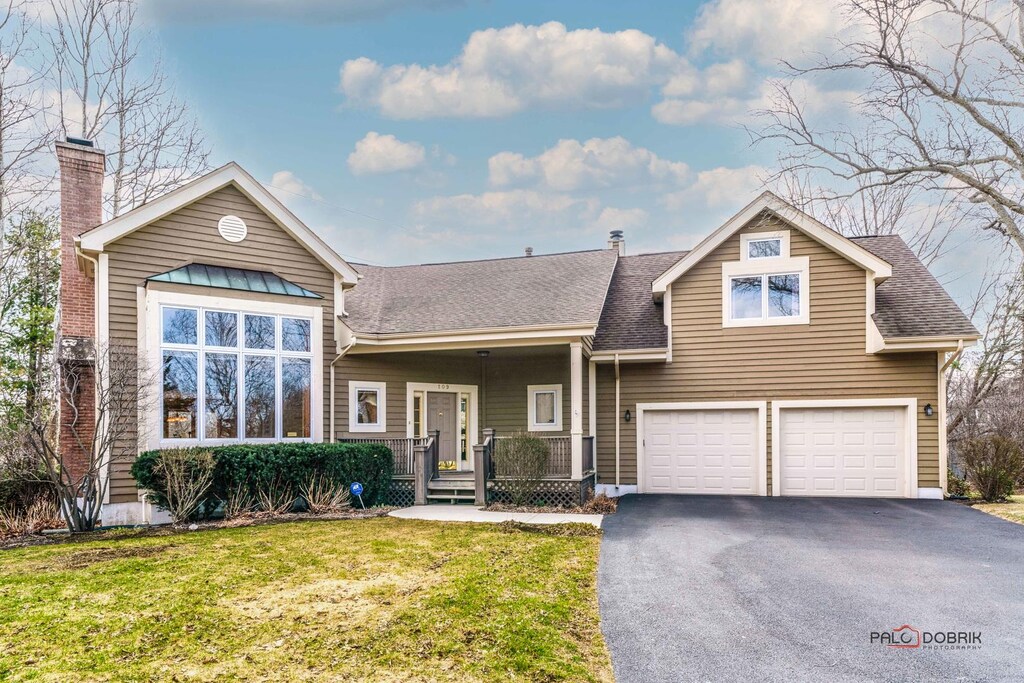 109 Thorne Grove Dr, Vernon Hills, IL 60061 - view of front facade with aphalt driveway, a porch, roof with shingles, a front lawn, and a chimney