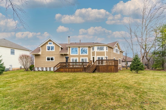 rear view of property with a deck and a lawn