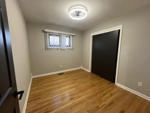 unfurnished bedroom featuring wood finished floors and baseboards
