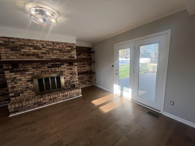 unfurnished living room with baseboards, a fireplace, and dark wood-style flooring