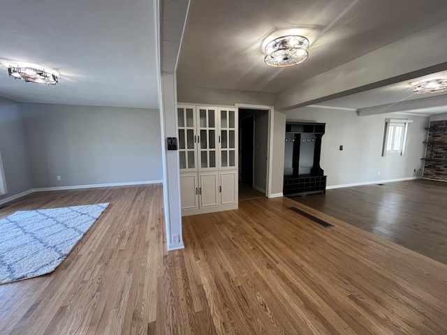 unfurnished living room featuring baseboards and wood finished floors