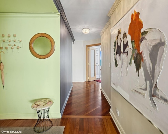hallway with wood finished floors, baseboards, and crown molding