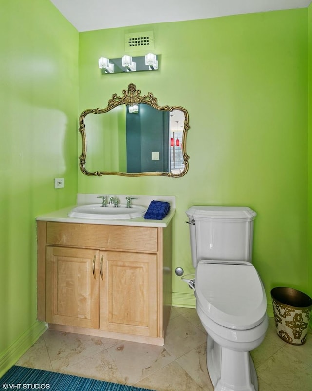 bathroom featuring toilet, vanity, baseboards, and tile patterned flooring