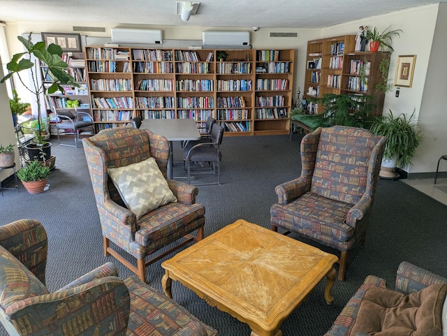 sitting room with carpet floors, a wall unit AC, and bookshelves