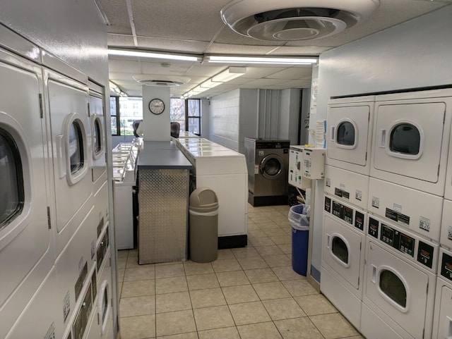 shared laundry featuring estacked washer and dryer, washing machine and dryer, and light tile patterned floors