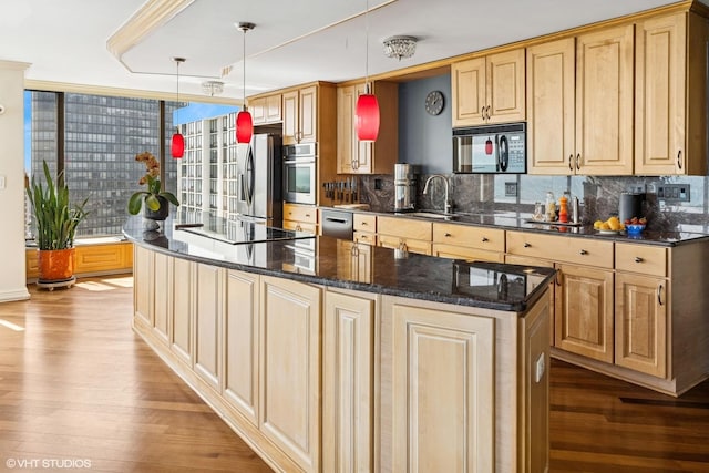 kitchen with black appliances, wood finished floors, backsplash, and a sink