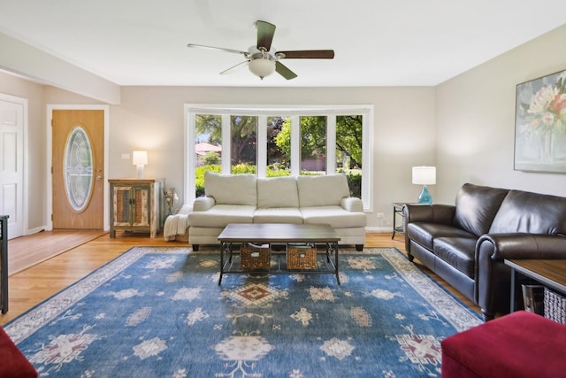 living room with baseboards, ceiling fan, and wood finished floors