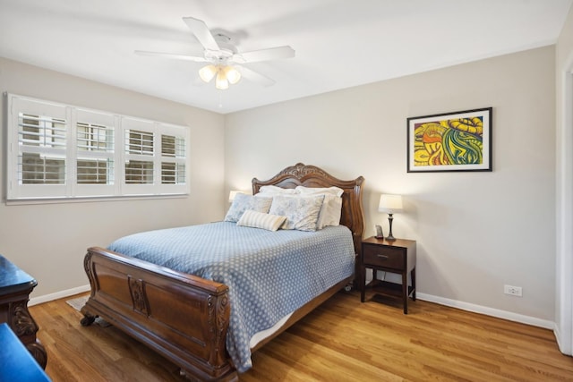 bedroom featuring baseboards, a ceiling fan, and wood finished floors
