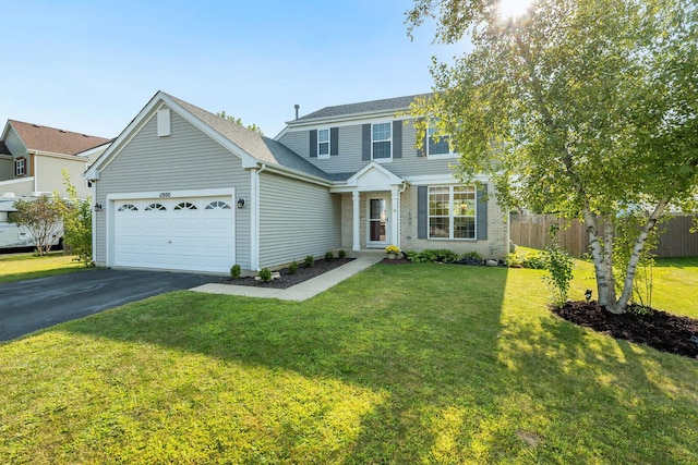 view of front of home with a front yard, fence, brick siding, an attached garage, and driveway