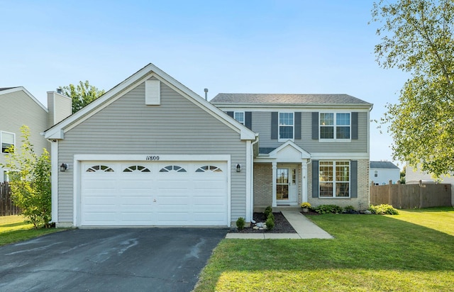 view of front of house with a front lawn, fence, a garage, and driveway