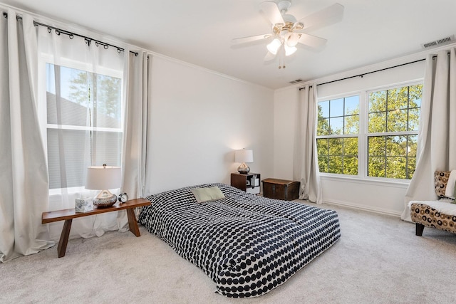 bedroom featuring carpet flooring, visible vents, and multiple windows